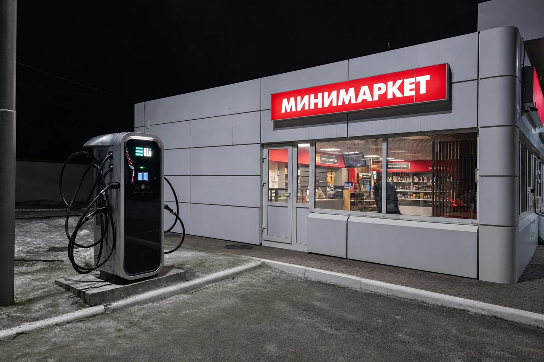 Зарядная станция ELLI 150 кВт у придорожного минимаркета ночью